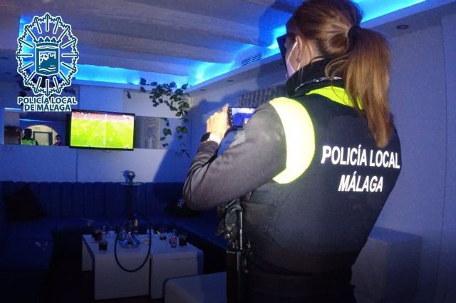 Agente de la Polica Local de Mlaga desalojando un bar que incumpla la normativa