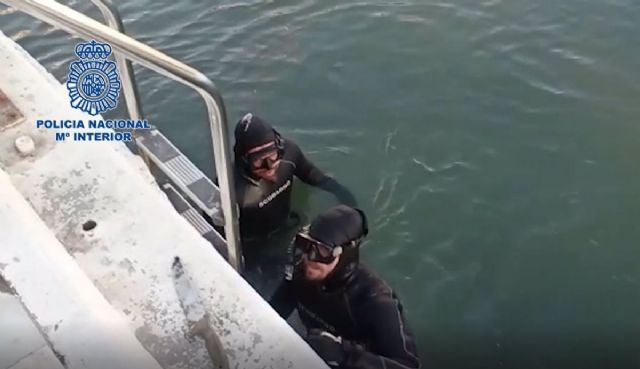 Dos buceadores de los GEO recuperan del fondo del mar un machete con el que un joven apual a un conocido