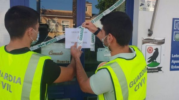 Agentes de la Guardia Civil precintan un establecimiento de Lotera en El Cuervo