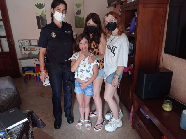 Un agente de la Polica Nacional de Huelva junto a la nia y su familia