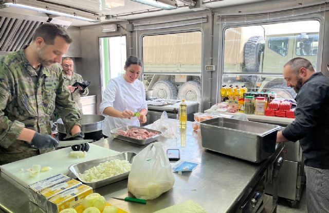 La cocinera y los militares elaboran el men